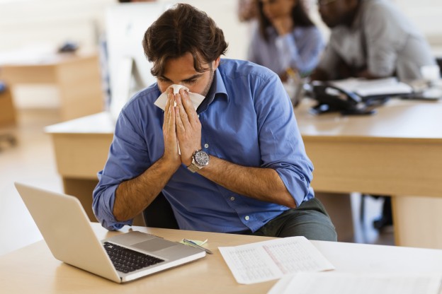 Guy covering nose while working
