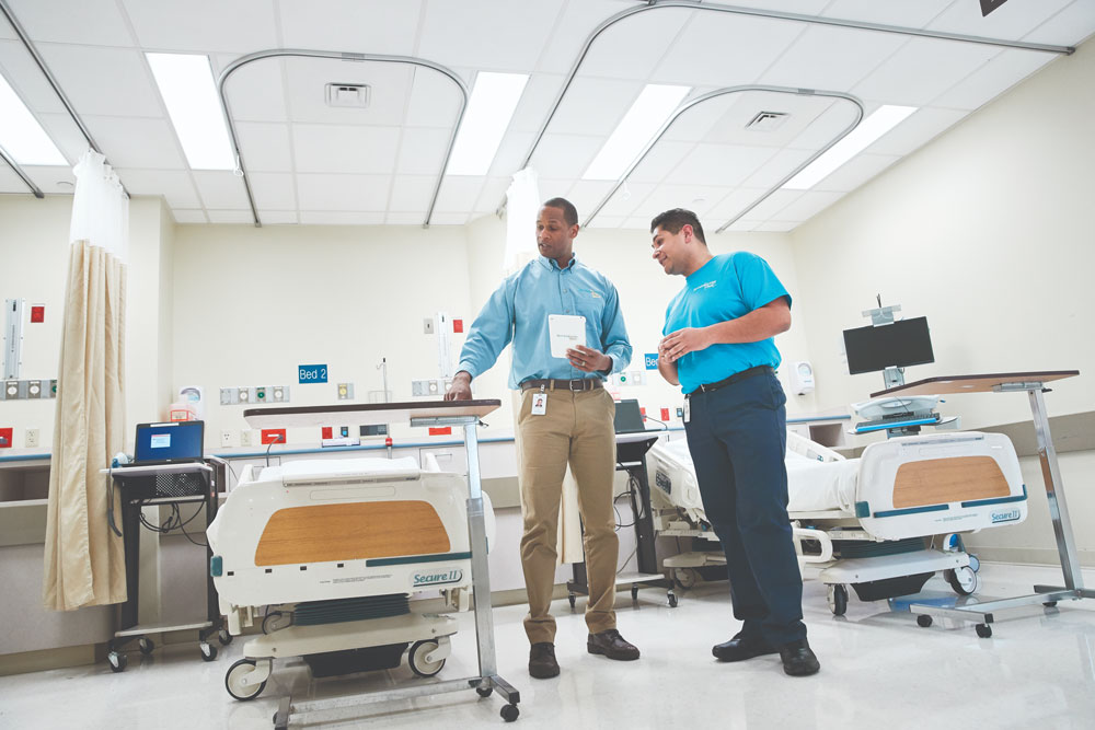 Two men inspecting hospital room